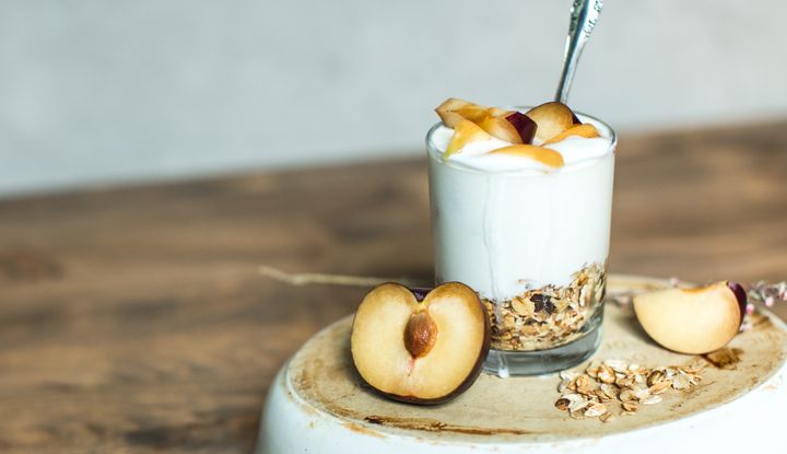 Schale mit M&uuml;sli, Joghurt, aufgeschnittene Pflaumen und Fr&uuml;hst&uuml;cksflocken