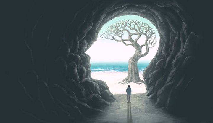 Was kommt nach dem Tod? Die Frage treibt die Menschen schon lange um Abstrakte Darstellung einer wie ein menschlicher Kopf geformten Höhle mit Baum in Form eines Gehirns